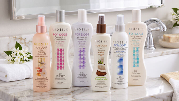 Six Biosilk for Dogs grooming products, including shampoos and detangling sprays, lined up on a marble counter.